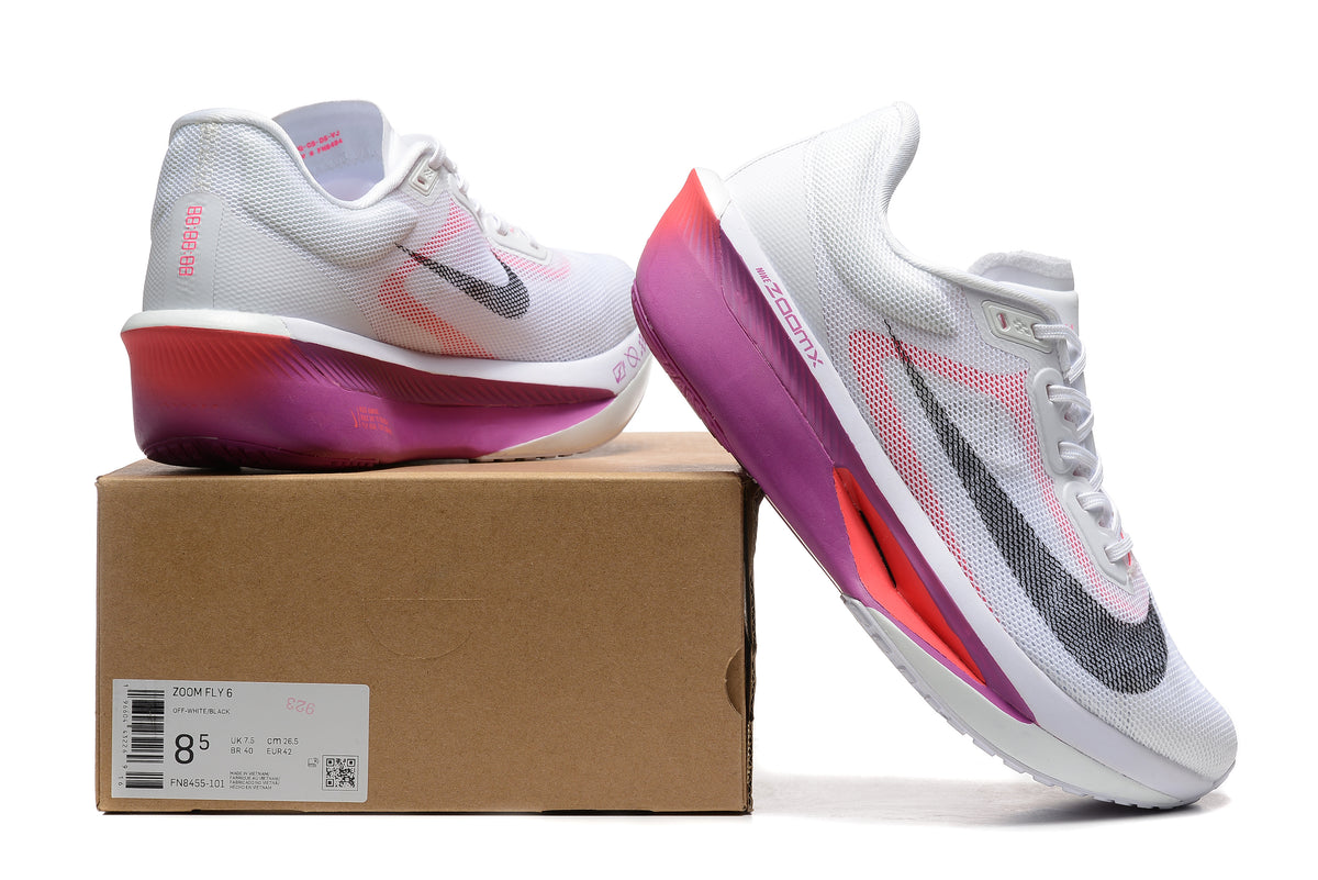 White Nike Zoom Fly 6 shoes with pink and purple accents beside a box showing a sample size label
