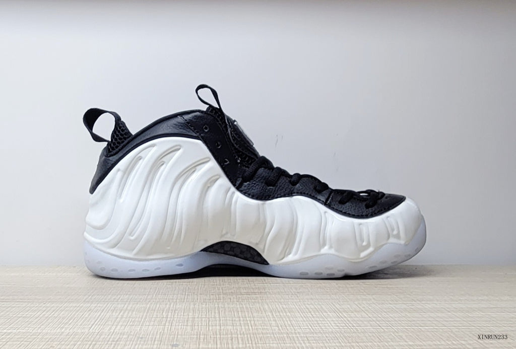 Side profile of a white Nike Little Posite One GS sneaker with black trim