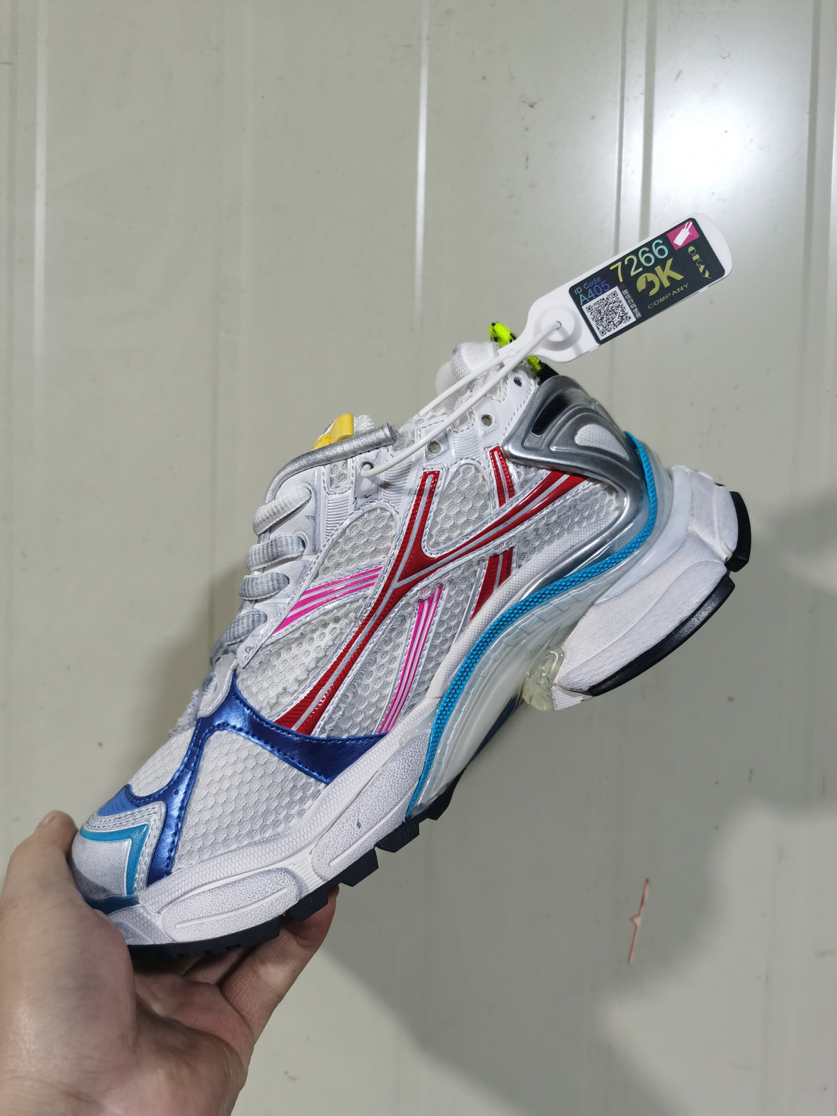 Close side view of the multicolor Puma Runner sneaker showing white mesh, red and pink overlays, blue toe accents, and a chunky sole.
