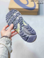 Close view of the sneaker outsole showing a deep, patterned tread in gray and dark purple.