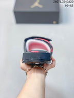 Rear view of the black slide showing the open heel, red interior accents, and adjustable upper strap.