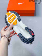 Underside view of a Nike Vomero 18 sneaker showing the patterned black outsole with orange sections.