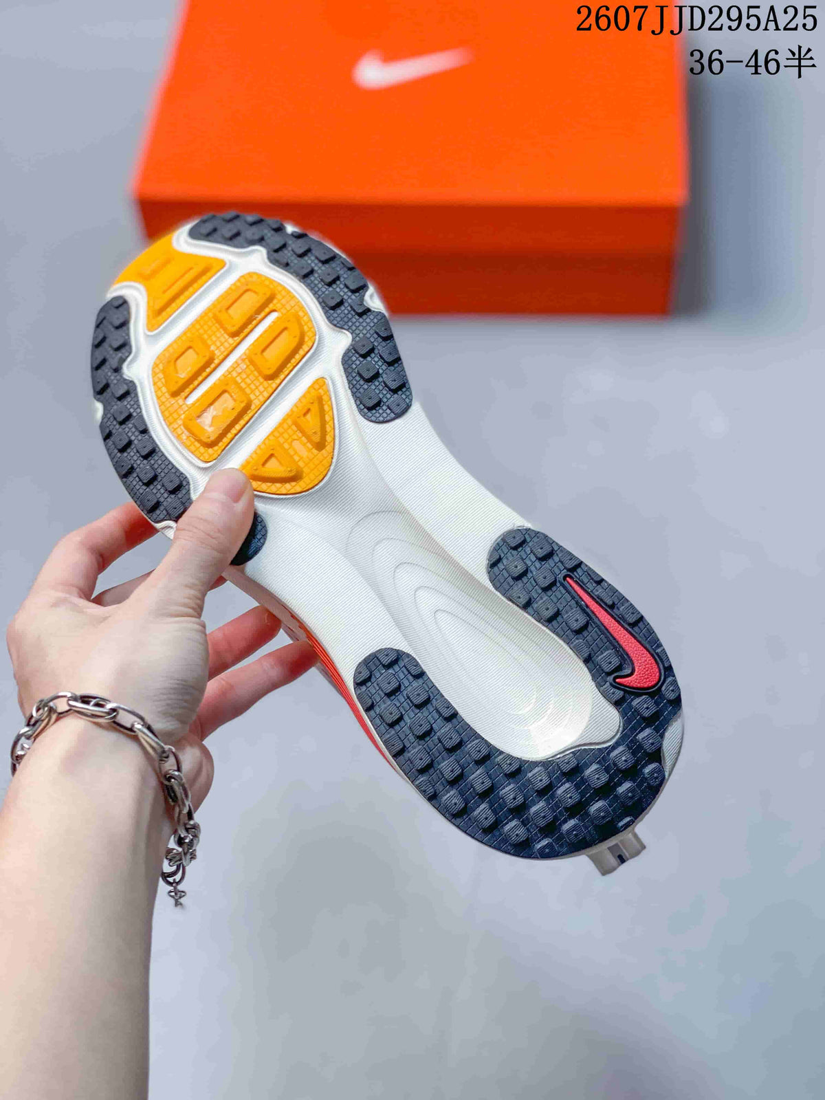 Underside view of a Nike Vomero 18 sneaker showing the patterned black outsole with orange sections.