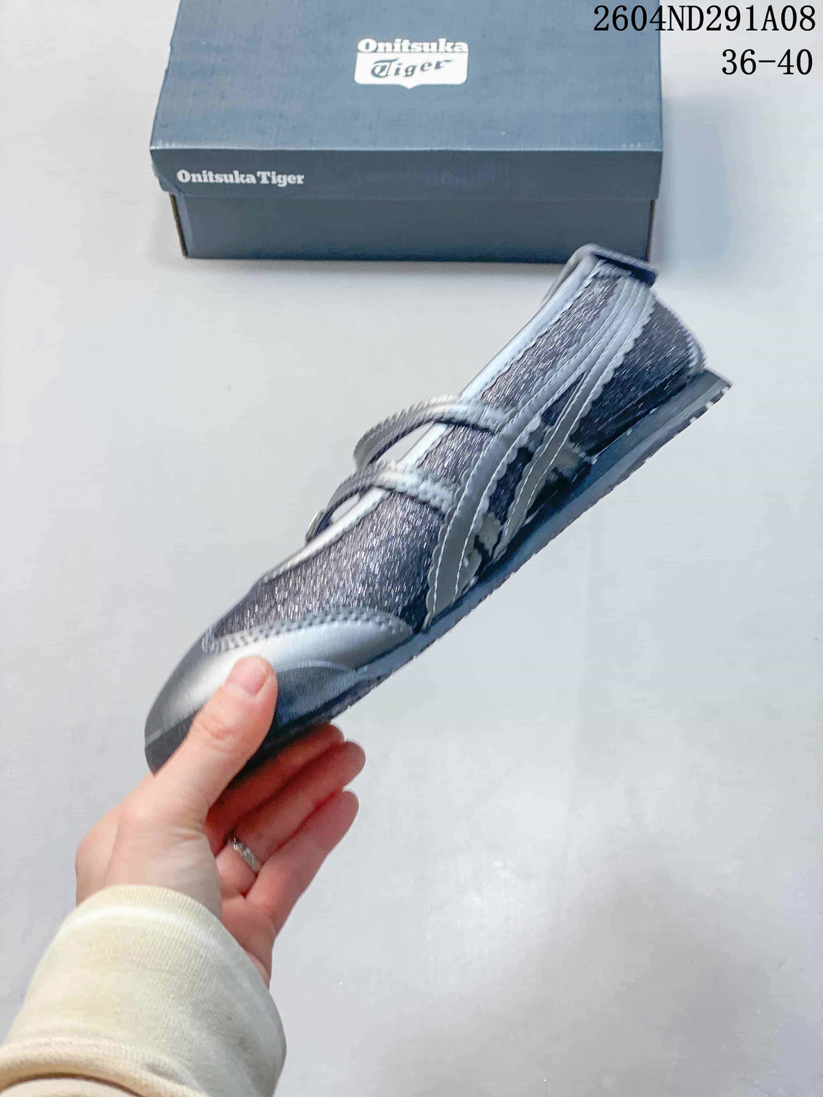 Side view of the low-profile sneaker showing the layered upper, buckle straps, and textured sole.