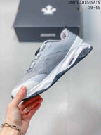 Side view of the grey and white low-top sneaker showing the layered upper and sculpted white midsole.