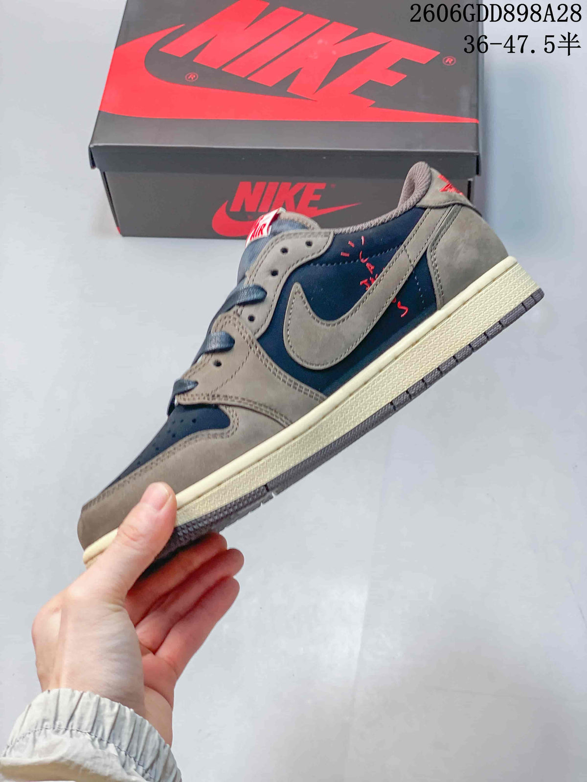 Side view of a navy and taupe sneaker with a light-colored reverse Swoosh
