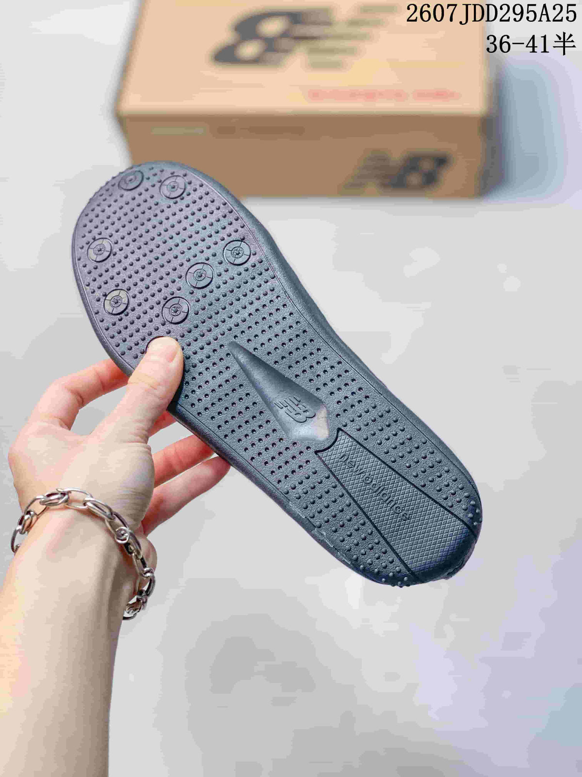 Close-up of the dark textured outsole showing its dotted tread pattern and molded branding.