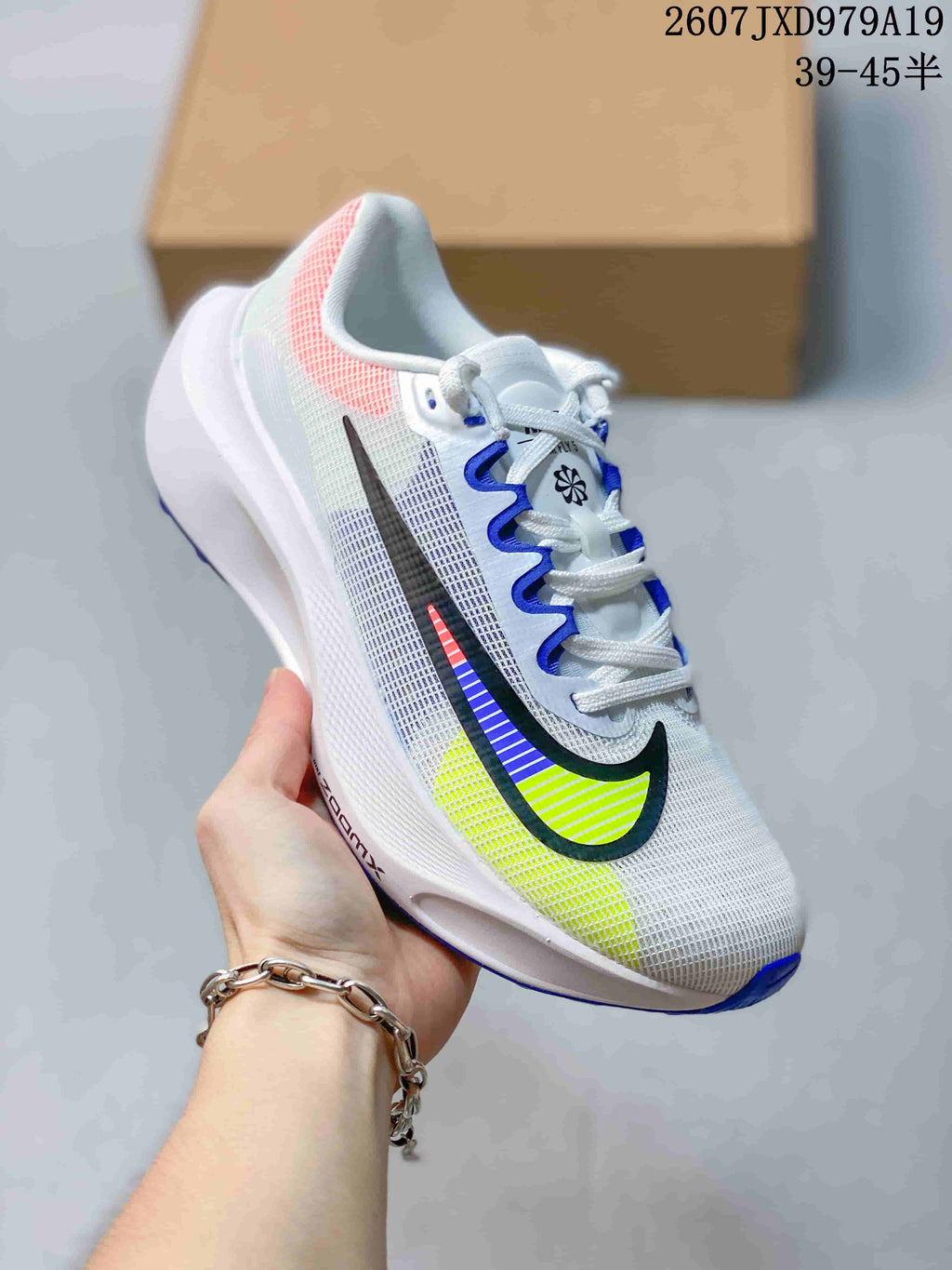Angled side view of the white Nike Zoom Fly 5 PRM running shoe with black, blue and neon yellow Swoosh accents.