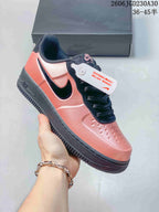 Angled side view of a coral-pink and black low-top sneaker with a side Swoosh and perforated toe; image overlay states EU sizes 36–45.5.