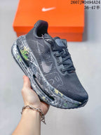 Angled side view of the sneaker showing the black and gray upper, side Nike branding, and multicolor patterned midsole.