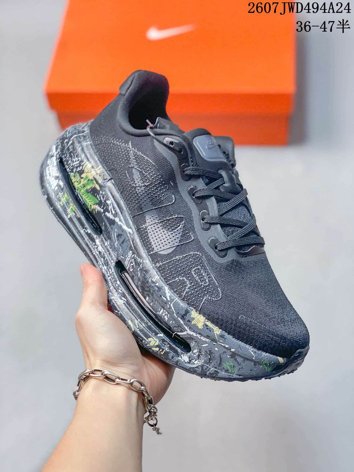 Angled side view of the sneaker showing the black and gray upper, side Nike branding, and multicolor patterned midsole.