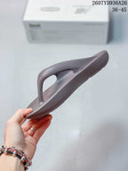 Side profile of the brown-purple thong sandal showing the toe post, upper strap, and molded sole.