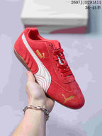 Red PUMA sneaker with a white side stripe, gold branding, red laces, and a gum-colored outsole.