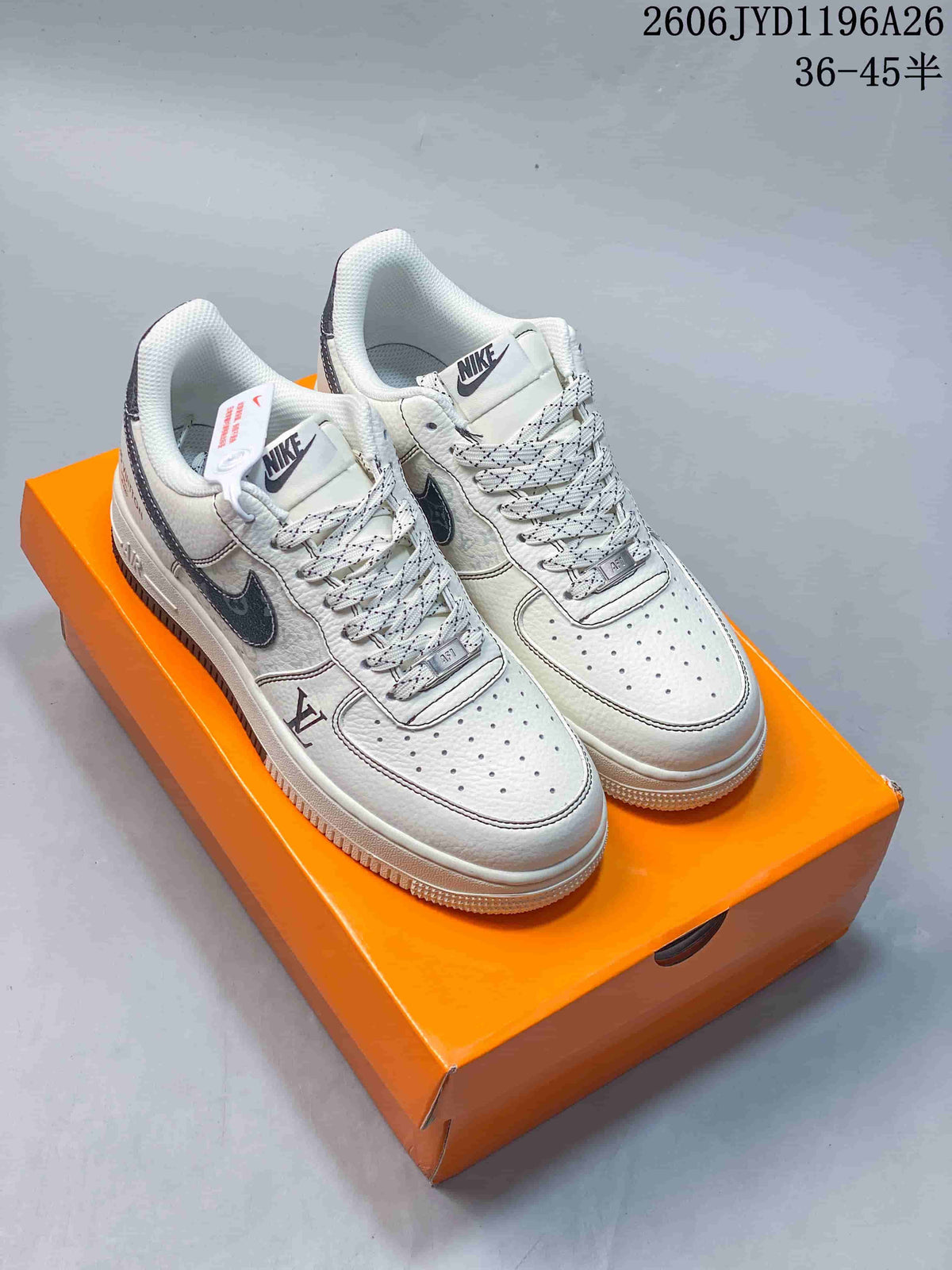 Pair of white low-top sneakers with patterned laces and dark accents