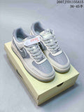 Pair of gray and blue Nike Air Force 1-style sneakers displayed on a shoebox, showing the patterned side panels, braided laces, and perforated toe boxes.