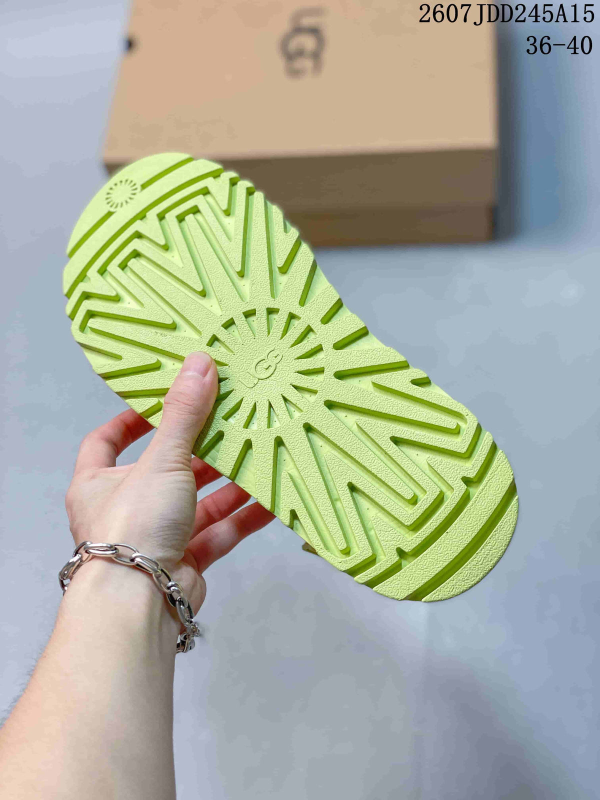 Bottom view showing the pronounced tread pattern on the lime green sandal outsole.