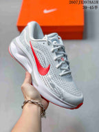 White Nike Journey Run sneaker with a bright red Swoosh-style logo and red outsole accents.
