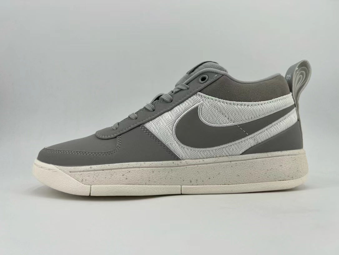 Side view of a gray and white Nike low-top sneaker with a Swoosh and speckled off-white sole