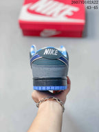 Rear view of the grey and blue sneakers showing the heel branding, blue outsole edge, and patterned collar lining.