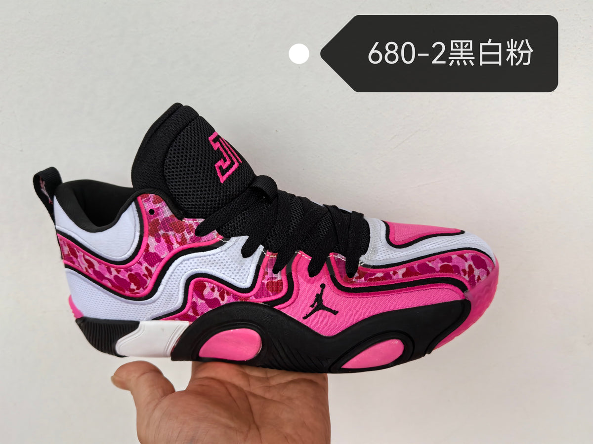 Jordan sneaker in black, white, and pink with patterned side panels, black laces, a Jumpman logo, and a number 23 design on the tongue