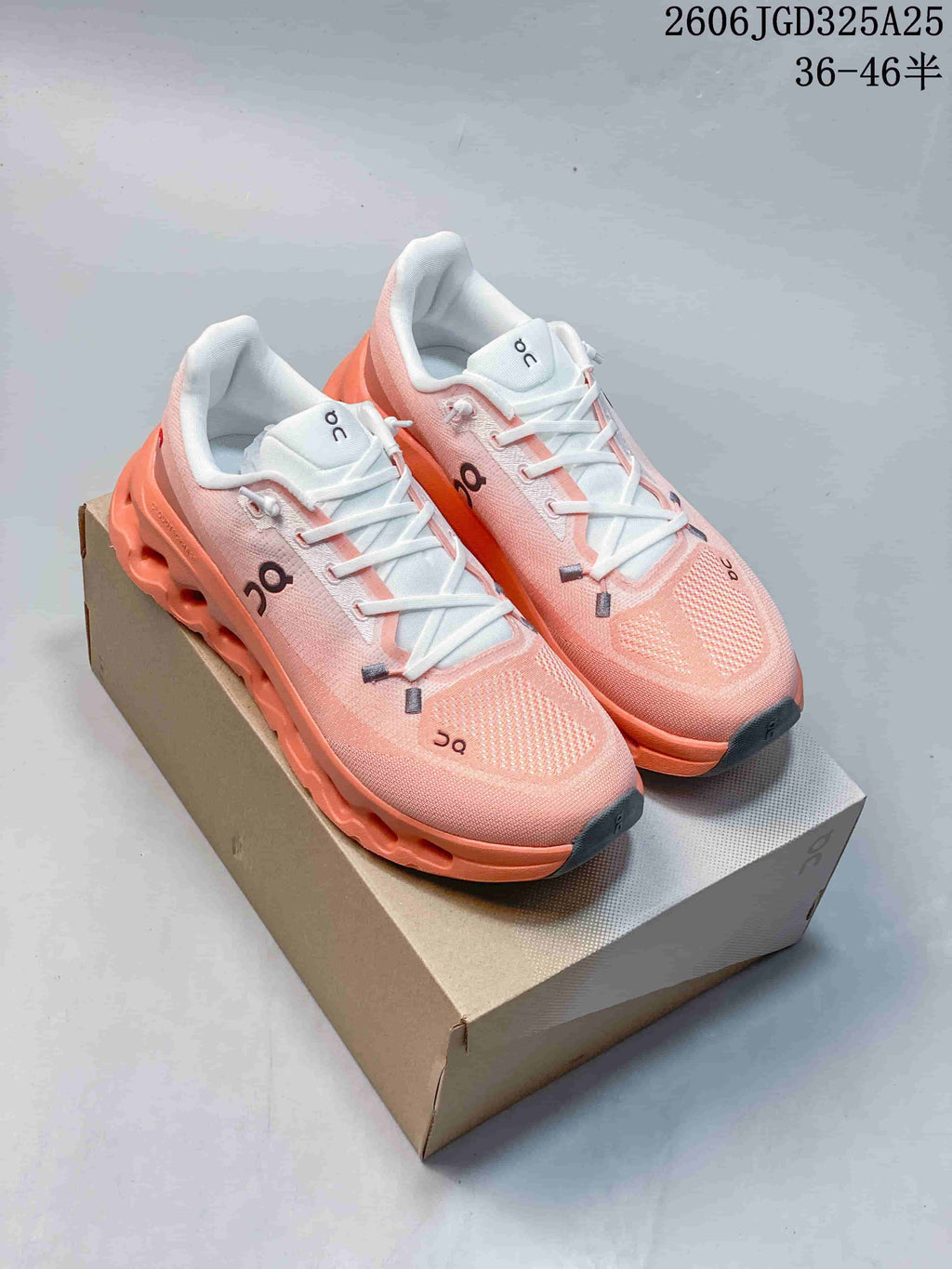 Pair of pink and coral On Cloudsurfer sneakers displayed on a shoebox, with the size range text 36–46 visible at the top.