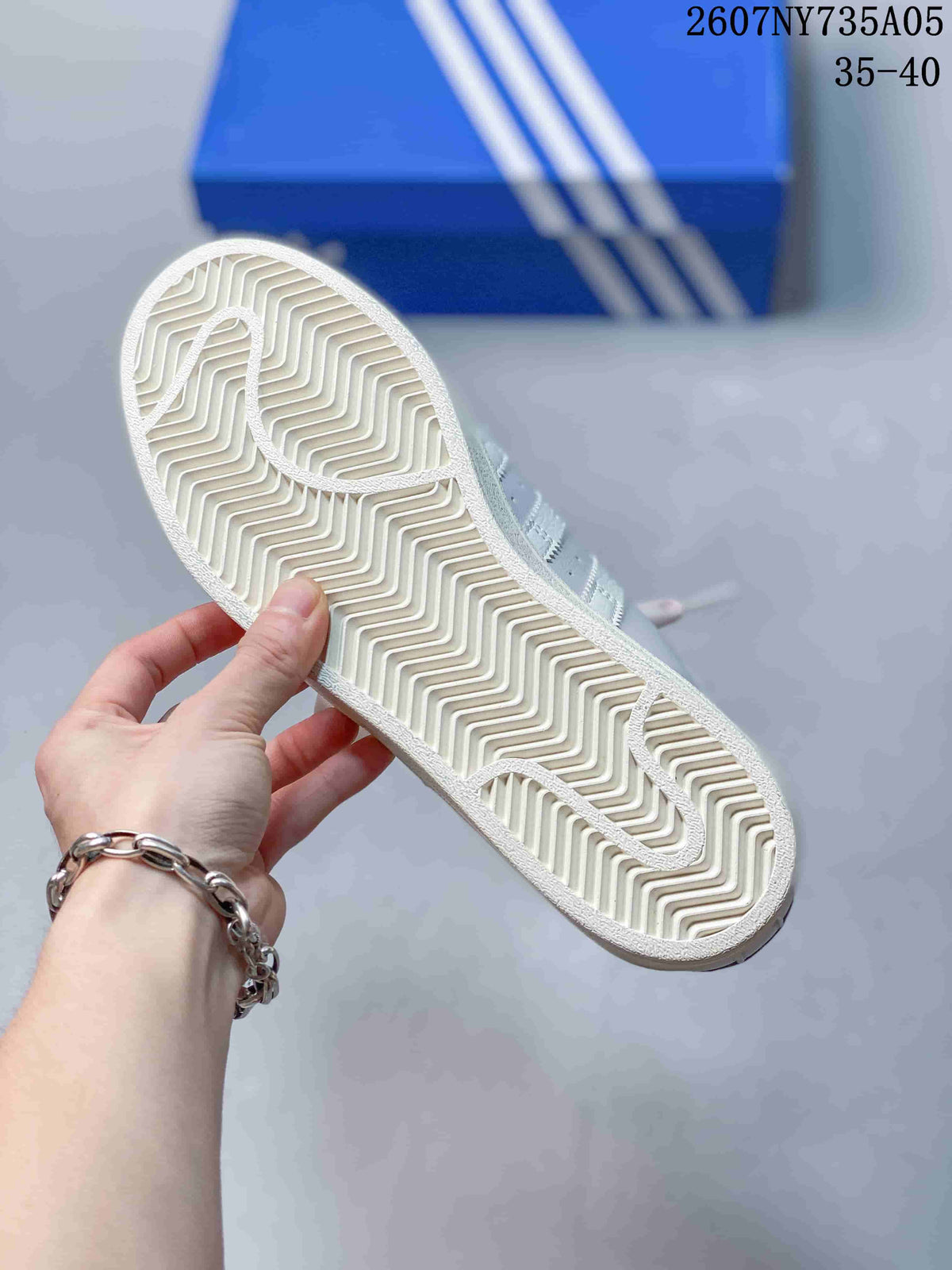 Underside view showing the textured zigzag rubber outsole of the white sneaker.