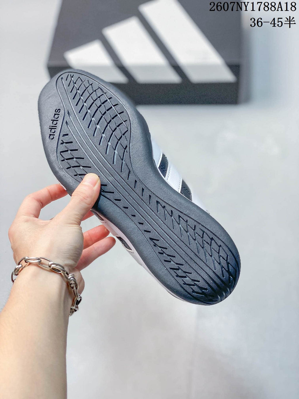 Close view of the patterned outsole on a navy adidas sneaker.