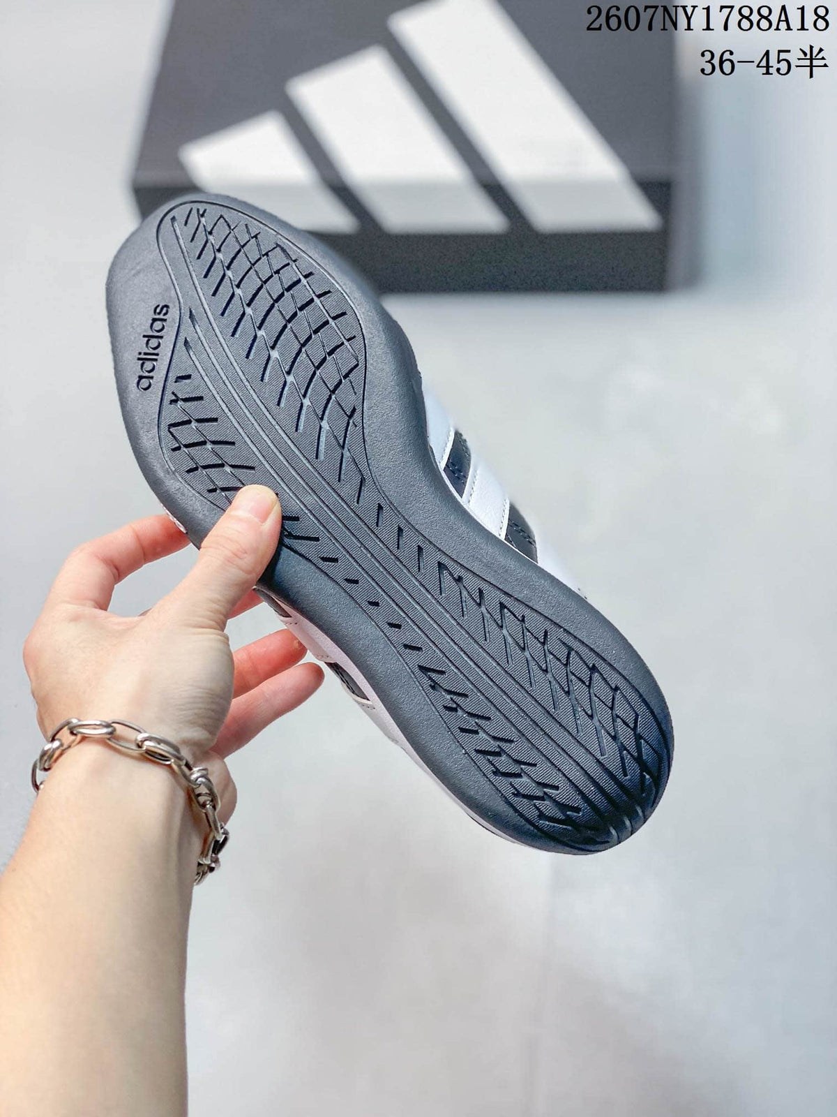 Close view of the patterned outsole on a navy adidas sneaker.