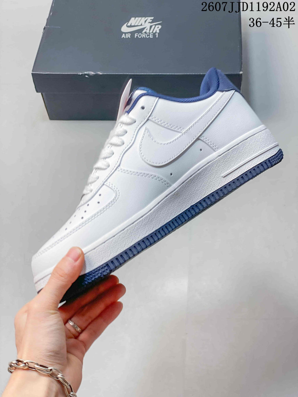 Side profile of a white low-top sneaker with navy accents
