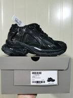Black Balenciaga Runner sneaker displayed on its box, with the box label showing style code 772767 W3RNY 0135 and size C 37.