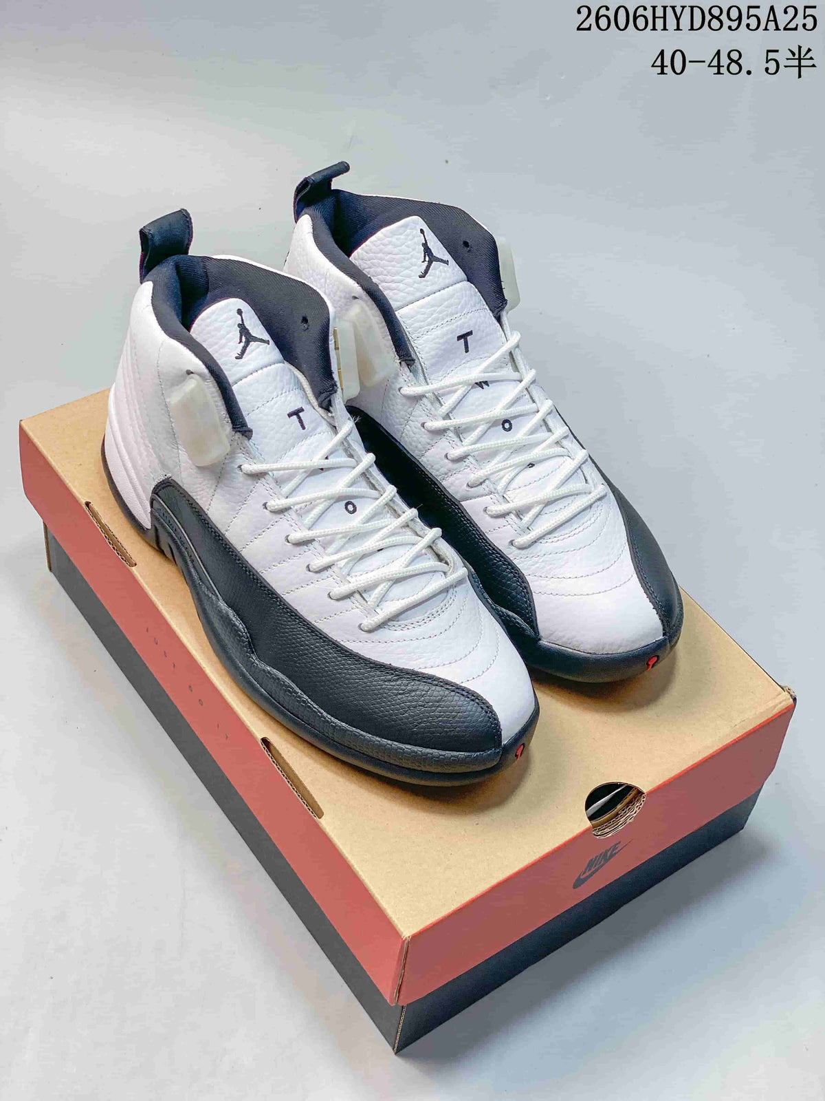 Pair of white and dark gray Jordan Air Jordan 12 high-top shoes displayed on a shoebox.