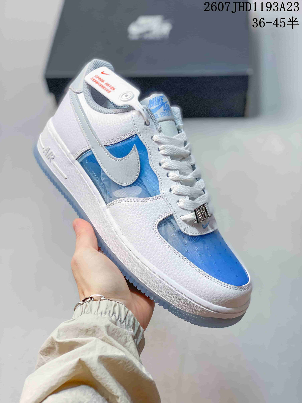 Angled side view showing the white and blue upper, Swoosh, Air midsole detail, and translucent outsole.