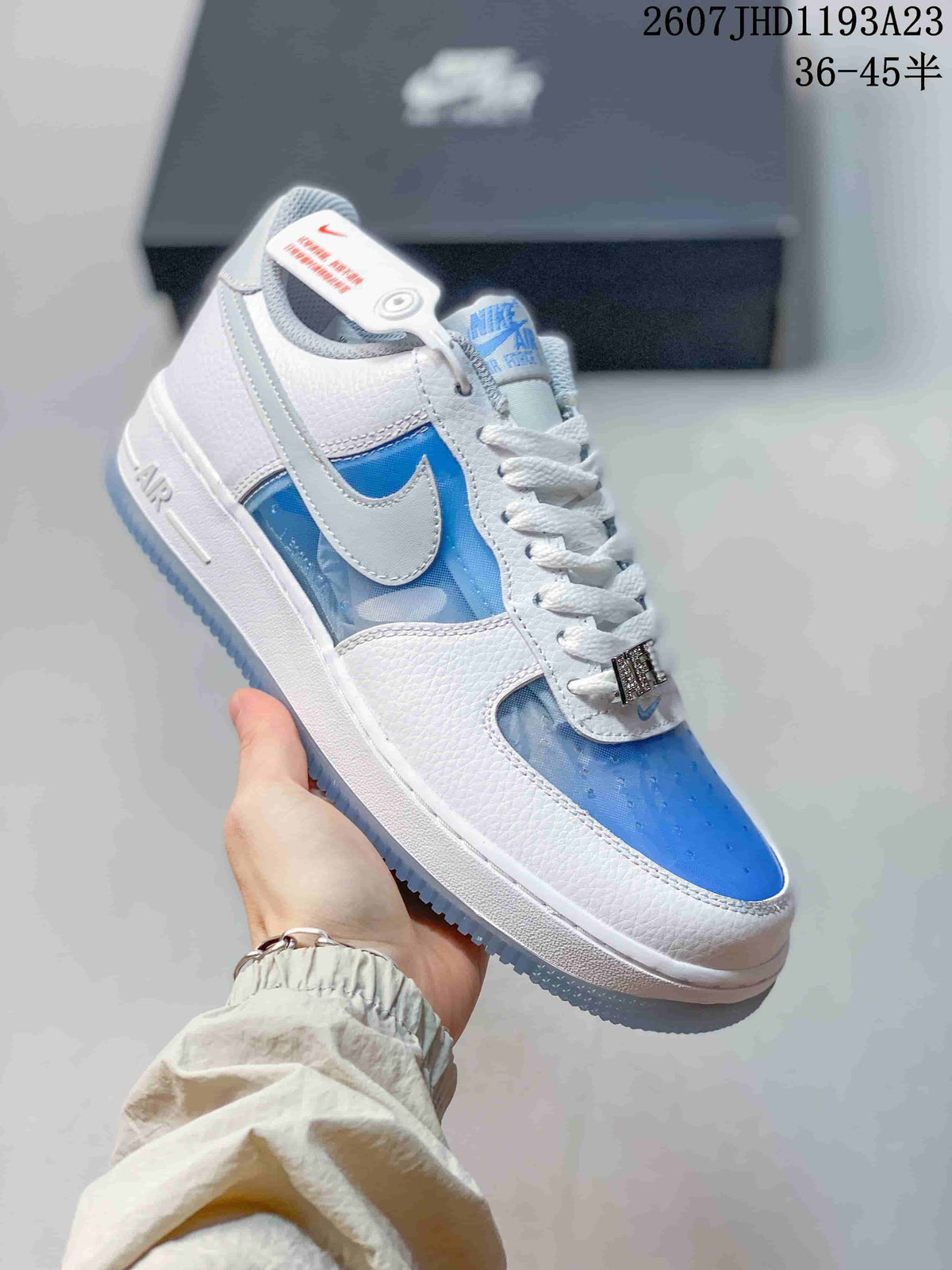Angled side view showing the white and blue upper, Swoosh, Air midsole detail, and translucent outsole.