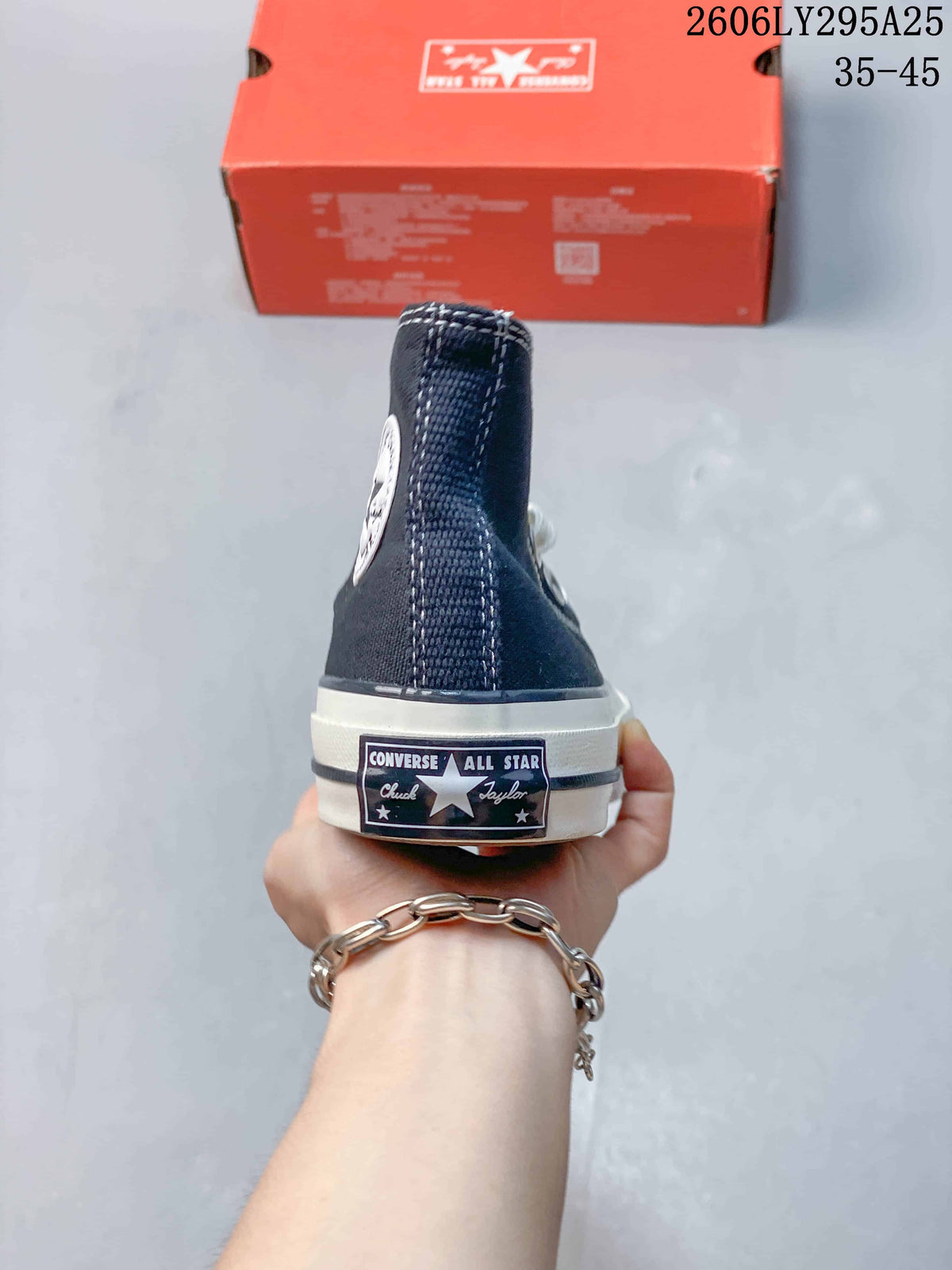 Rear view of the navy high-top sneaker showing the Converse All Star heel label and white midsole.