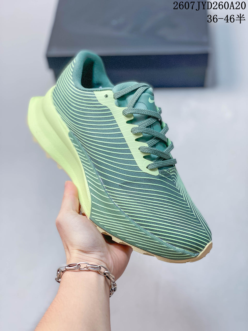 Angled side view showing the green patterned upper, lime overlays, and trail-style outsole.