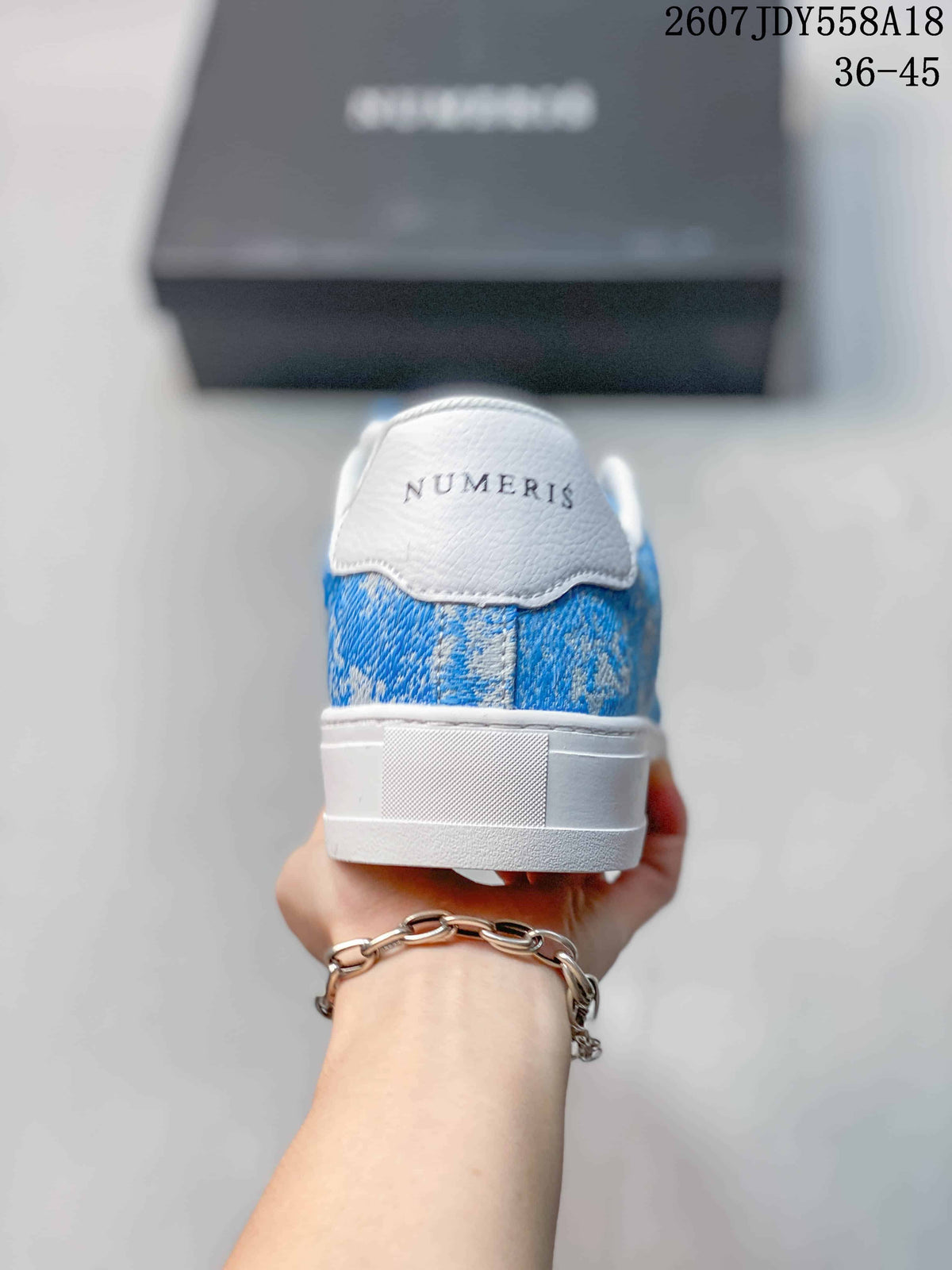 Rear view of a blue and white NUMERIS sneaker showing the branded heel and raised white sole.