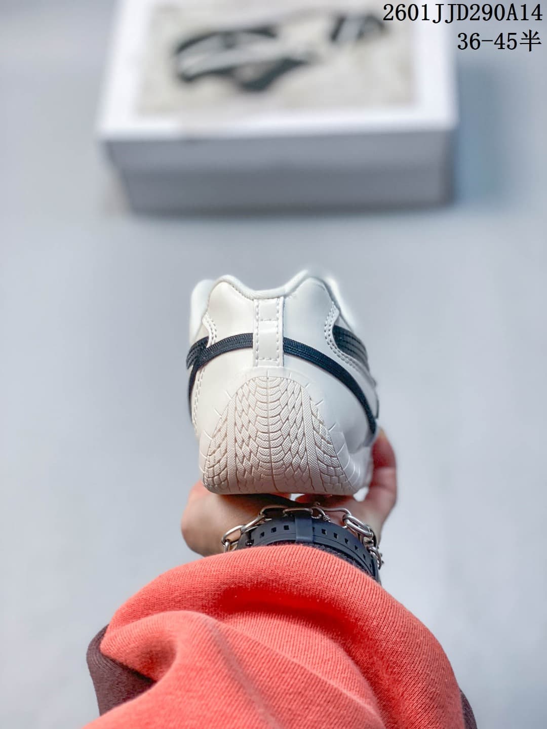 Rear view of the off-white and navy PUMA sneaker showing the heel construction and outsole pattern.