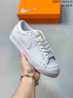 Angled view of a white Nike Blazer Low Premium sneaker with a tonal Swoosh, white laces and a textured rubber sole.