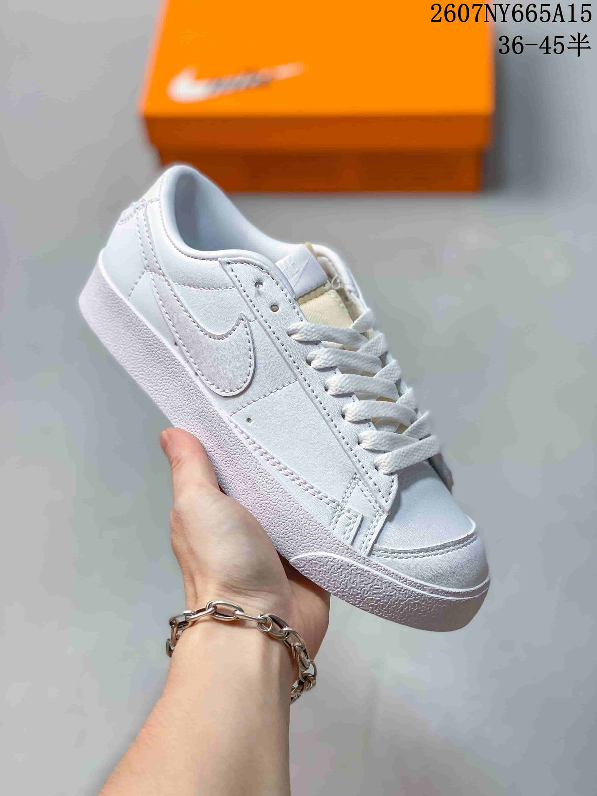 Angled view of a white Nike Blazer Low Premium sneaker with a tonal Swoosh, white laces and a textured rubber sole.