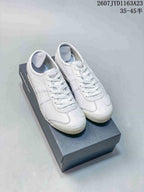 Pair of white and pink Onitsuka Tiger Mexico 66 SD sneakers displayed on a shoebox.