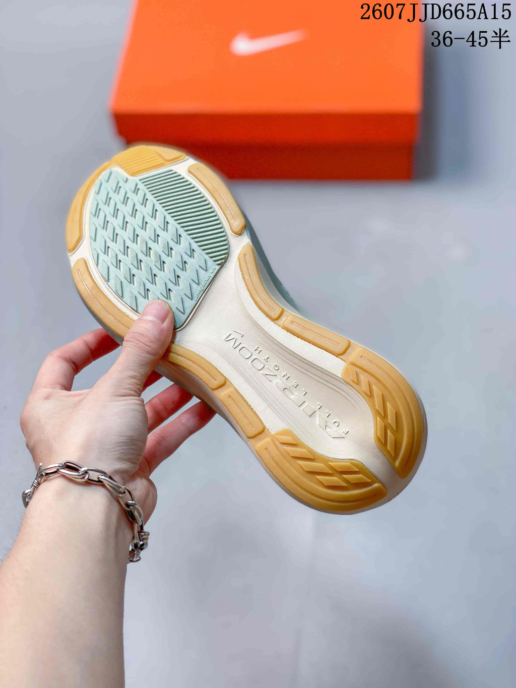 Bottom view of a Nike Pegasus 42 sneaker showing the patterned outsole and gum-colored rubber sections.