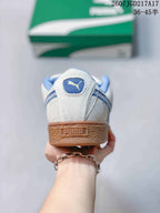 Rear view of the sneaker showing the blue collar, PUMA heel branding, and gum-colored textured heel section.