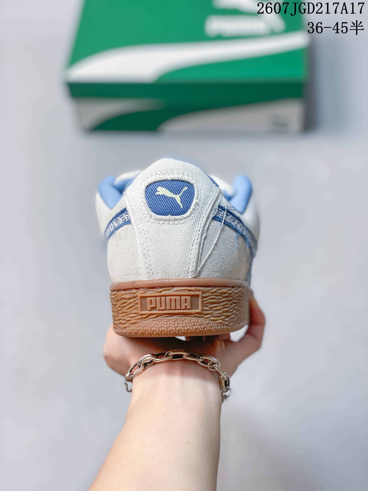 Rear view of the sneaker showing the blue collar, PUMA heel branding, and gum-colored textured heel section.