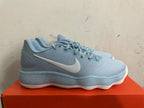 Side view of a light blue Nike basketball shoe with a white Swoosh and ridged sole.