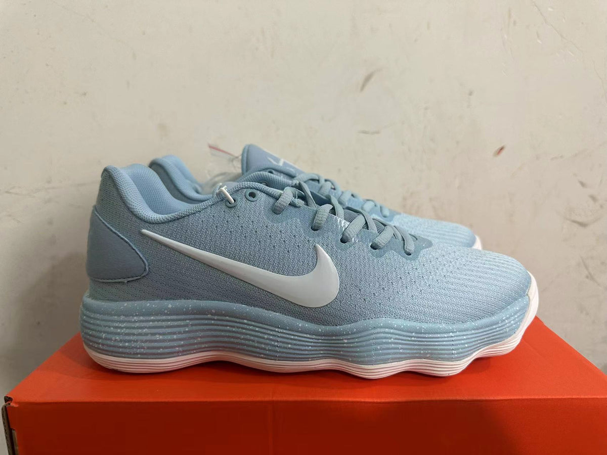 Side view of a light blue Nike basketball shoe with a white Swoosh and ridged sole.