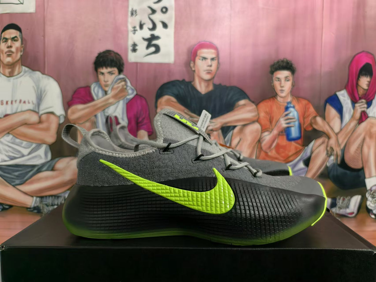 Side view of gray and black Nike sneakers with a lime-green Swoosh