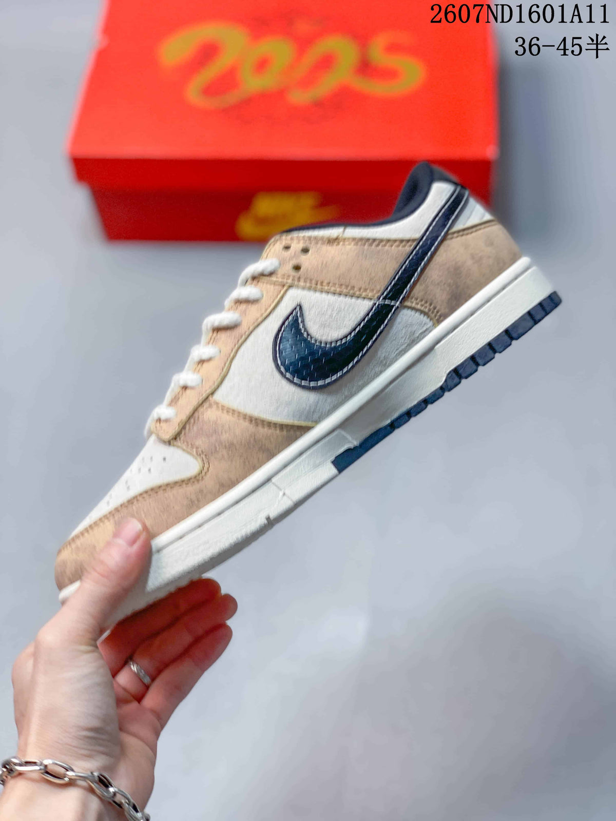 Side view of a low-top sneaker showing layered tan and white panels, a dark textured Swoosh, white midsole, and navy outsole.