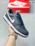 Black and white Nike SB Dunk Low Pro sneaker with a white Swoosh and dark outsole, photographed beside a red shoebox.