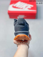 Rear view of the black sneaker showing the heel branding, heel air unit and gum-colored outsole.