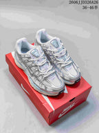 Pair of silver and white Nike P-6000 sneakers with pale blue accents on a red shoebox